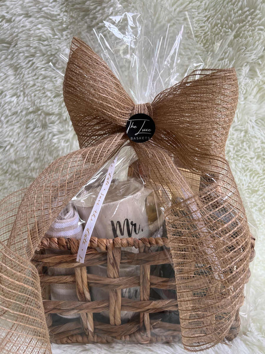Gift basket wrapped with a large brown bow on a textured white surface