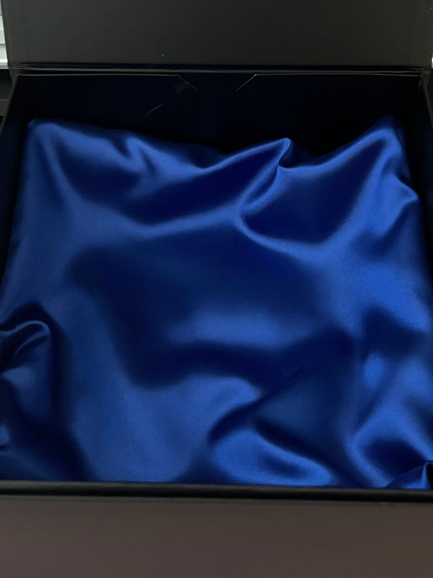 Black open box with blue interior on a desk