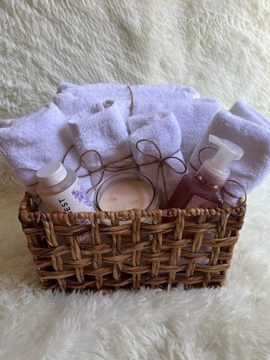 Wicker basket with towels and skincare products on a fluffy white surface